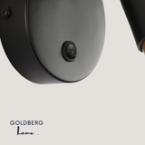 Close-up of integrated on-off switch button on Goldberg Nacht Luxe wall lamp base.